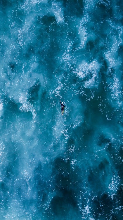 man practising surfing skills in deep water